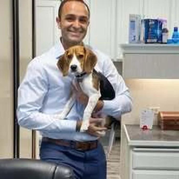 Dr. Edmond Ahdoot holding his dog at the office