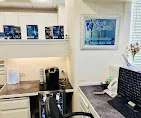 Consultation room detail with Smiles by Eddie wall sign and office cabinetry