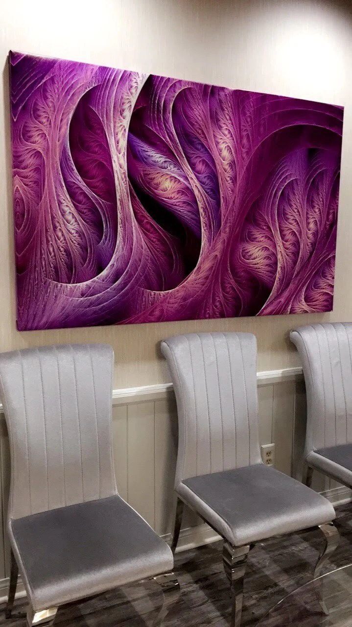 Waiting room chairs beneath purple wall art